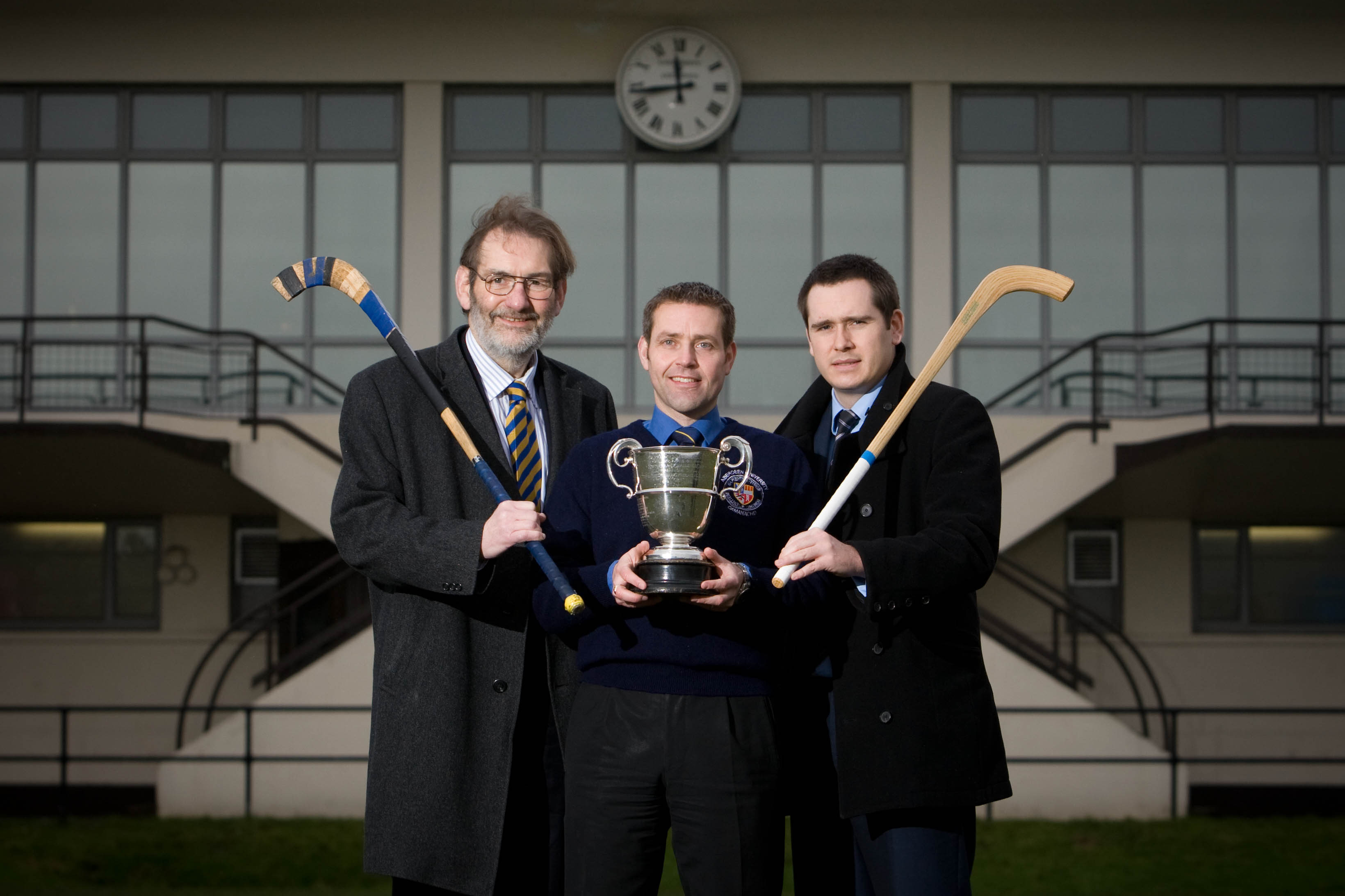 Prof Diamond with two shinty players and the Sutherland cup